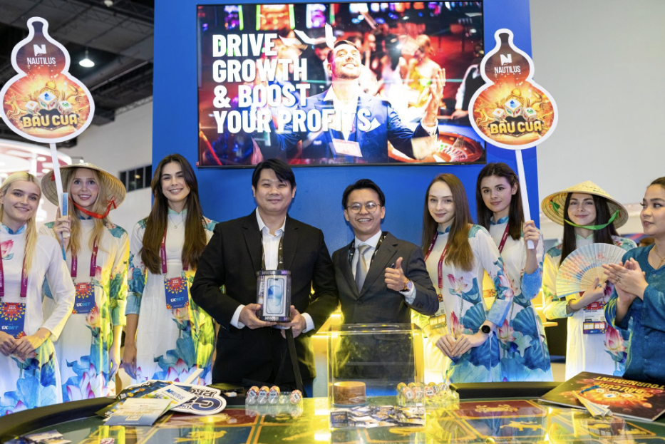 Photo with Nautilus Games C.O.O Lucas Cheng posing at the stand with a lucky winner of an iPhone 15